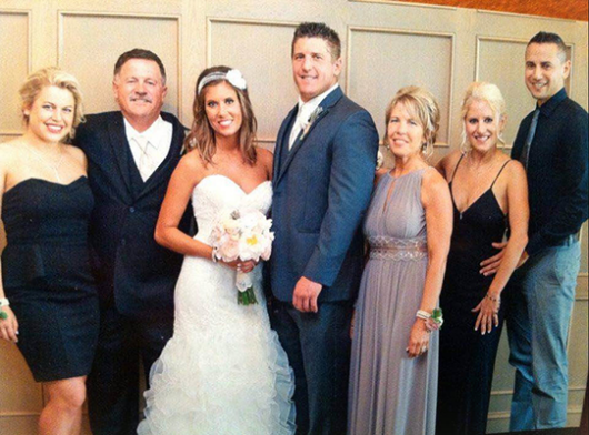 A bride and groom posing with their family.